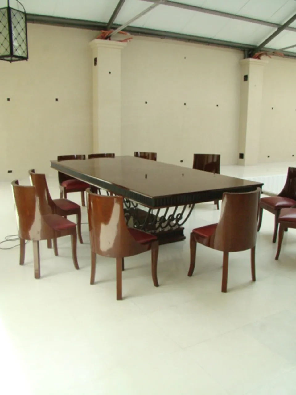 Antique dining table with Art Deco design for 12 people, surrounded by elegant chairs.