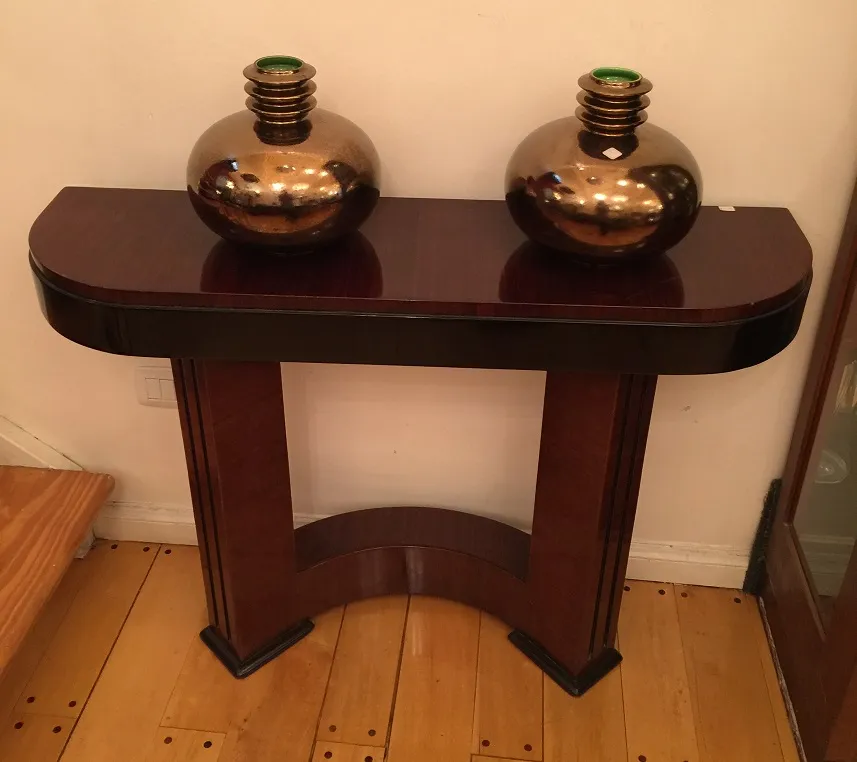 antique consoles with decorative vases on top