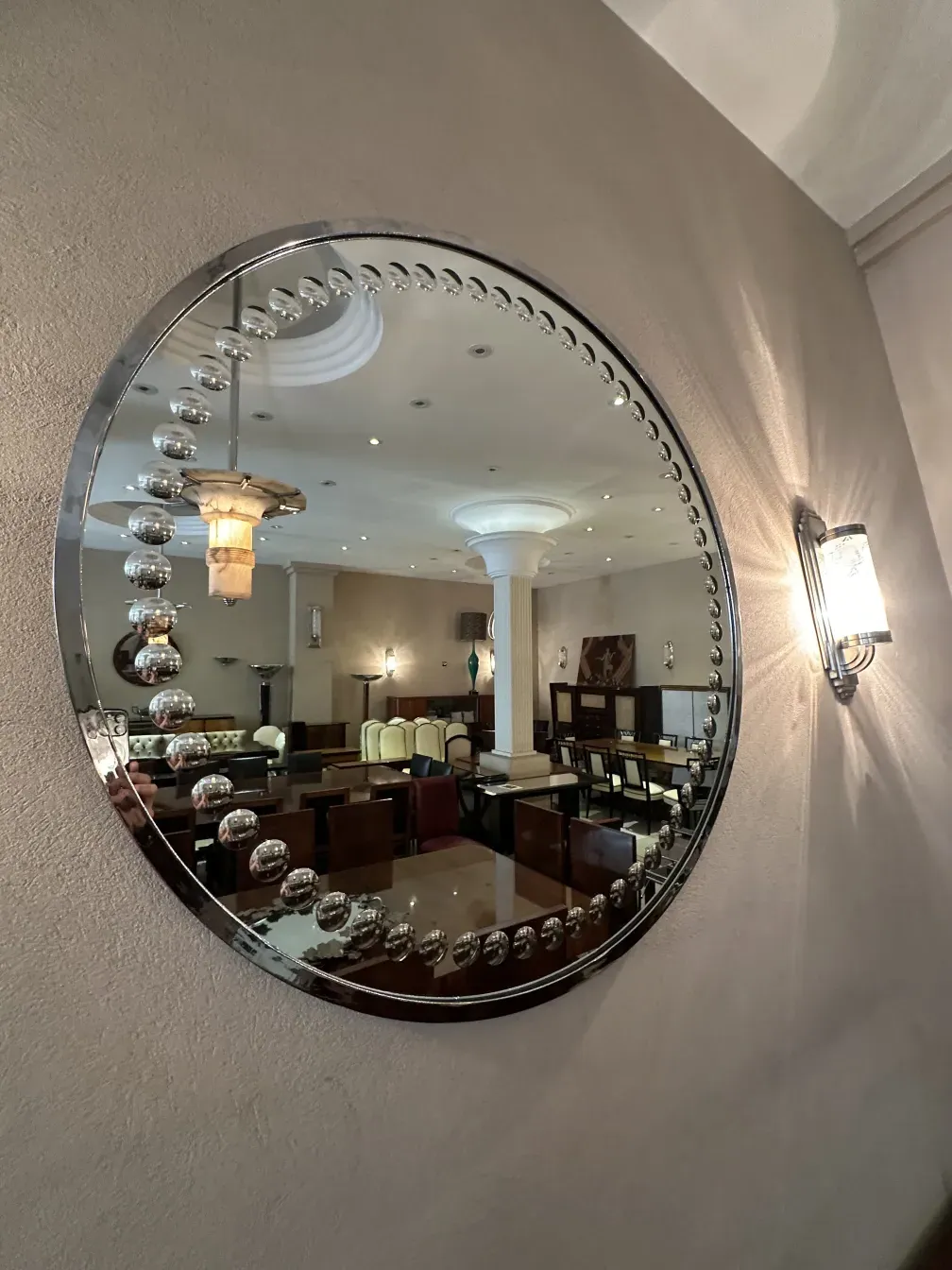 antique round mirror in an elegant setting, with lights and a cozy background