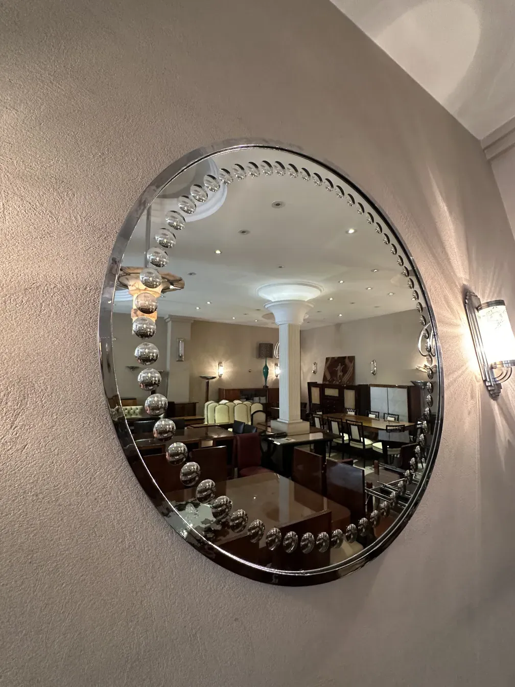 antique art deco mirror with shiny embellishments on the wall