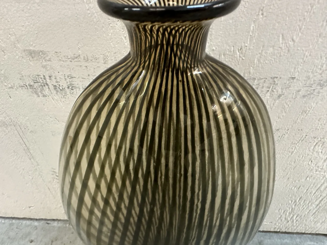 Antique Murano vase with prominent stripes, cozy ambiance.