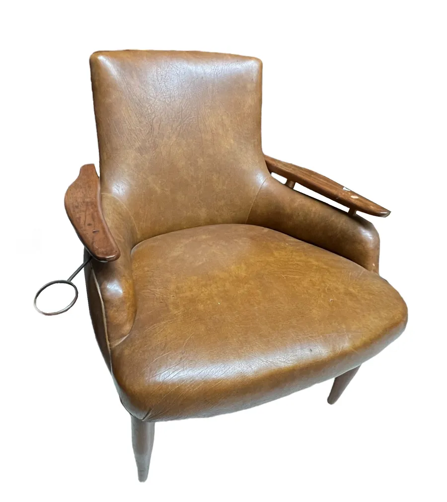 antique armchair with arms, brown leather and elegant design in a classic setting.