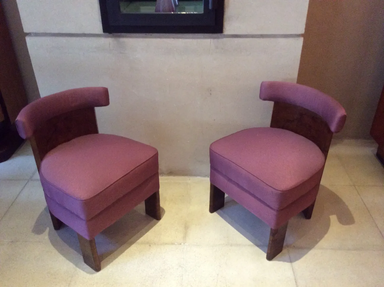 two antique armchairs with curved arms, upholstered in scarlet, set in a cozy environment.