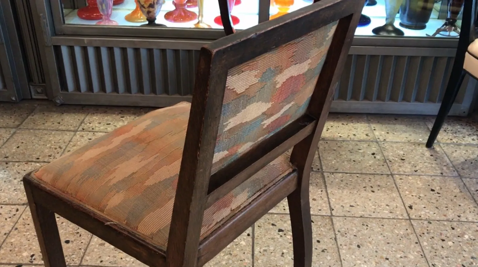 sedia antica con schienale decorato in un ambiente di antiquariato