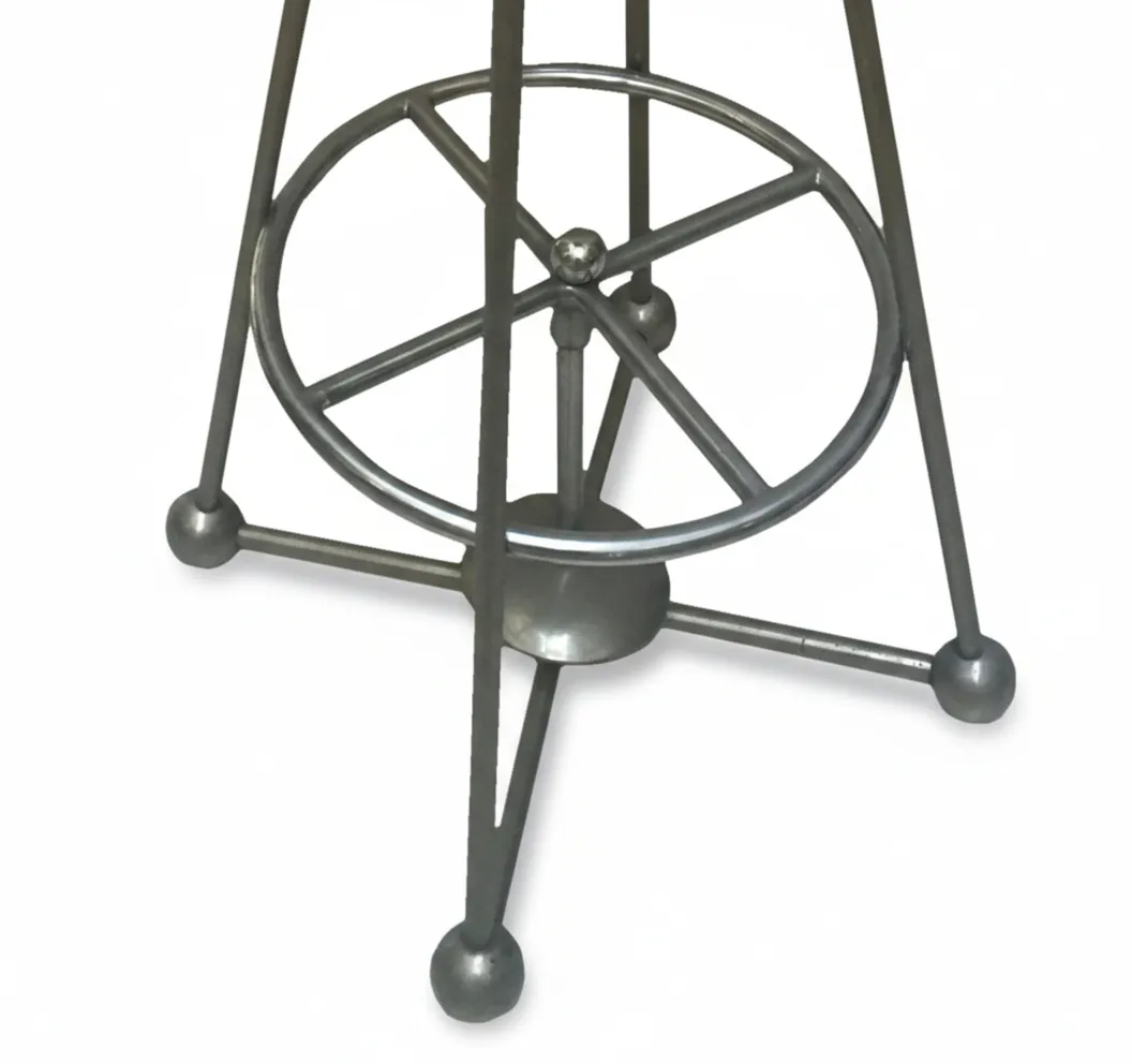 Dettaglio di uno sgabello antico con base in metallo decorativo.