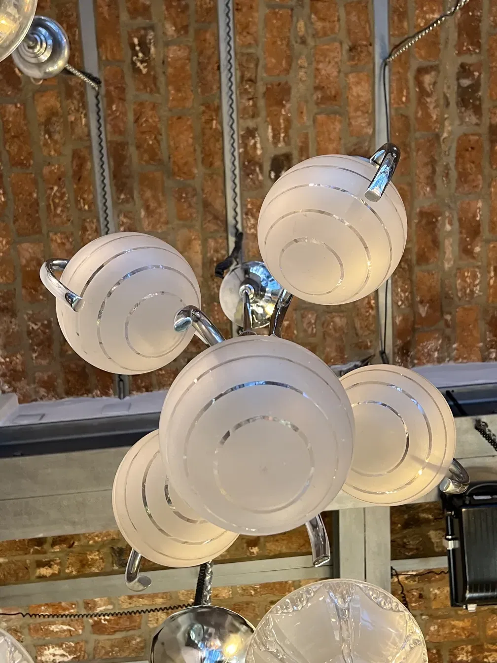 Antique hanging lamp Art Deco with white spheres in an industrial setting. Brick background.