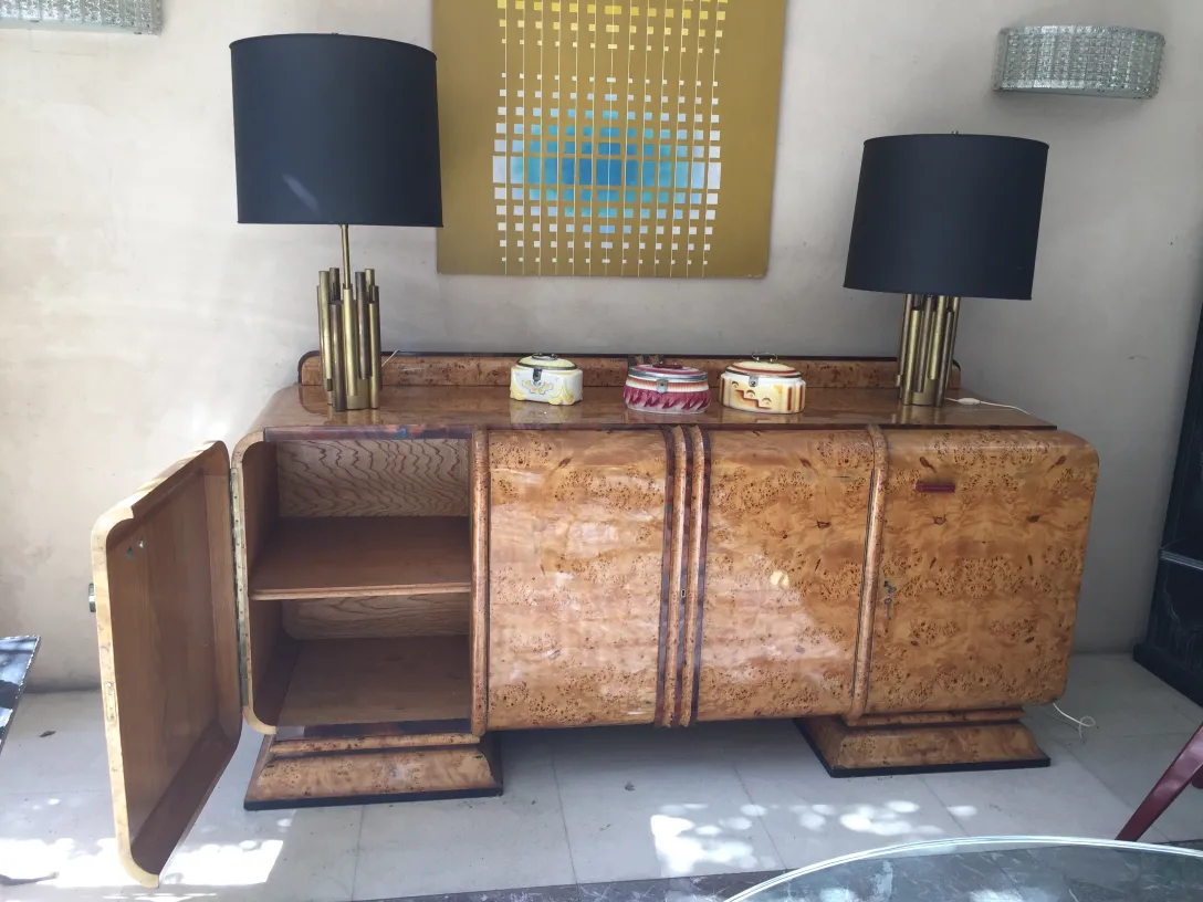 luminária de mesa antiga art deco com cúpula preta e base dourada, decorando um móvel