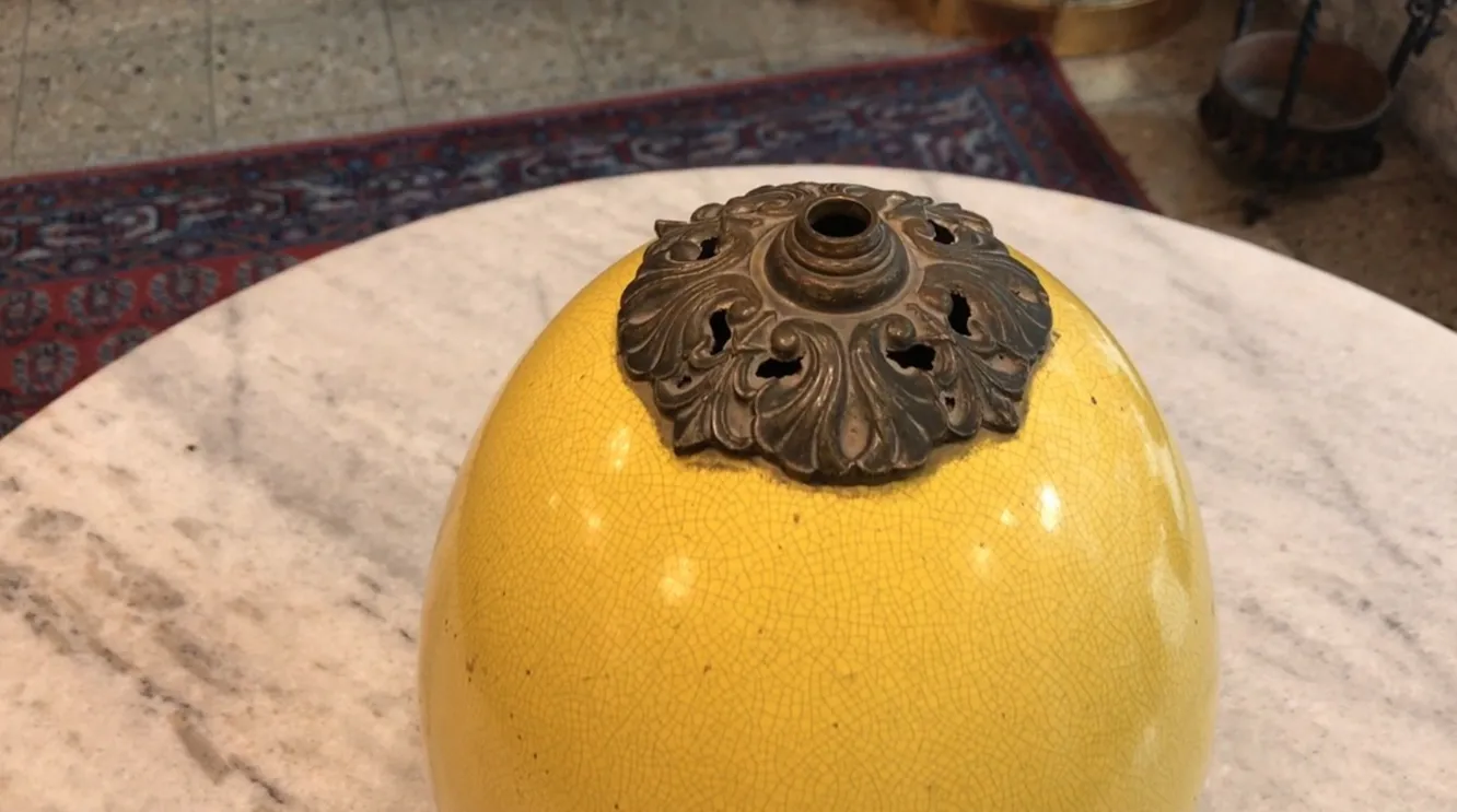 Luminária de mesa antiga em art deco amarela com detalhes decorativos.