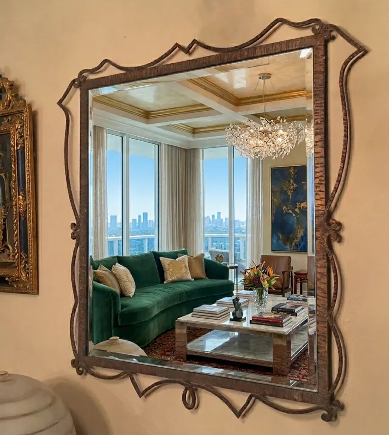 antique mirror with decorative frame in an elegant room with green sofa