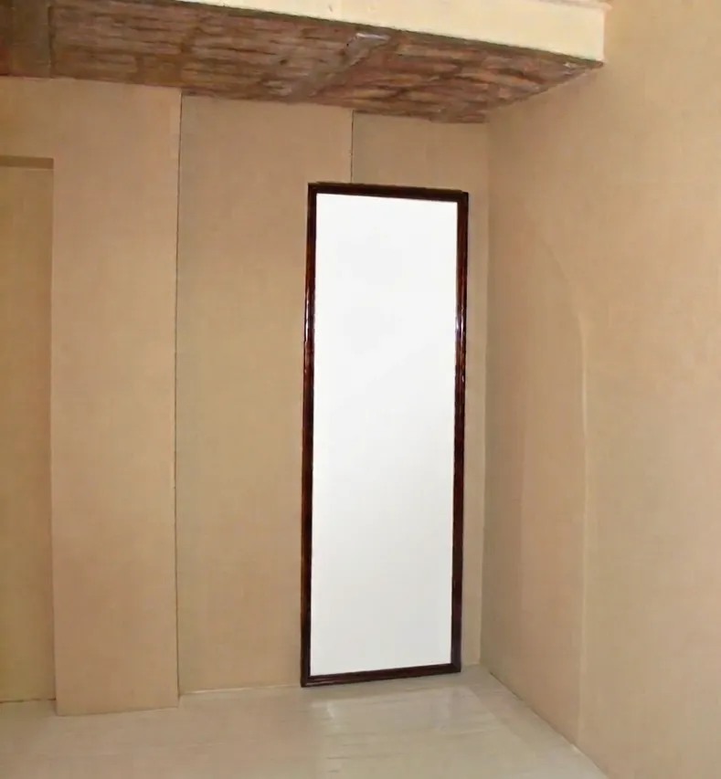 antique wall mirror with dark frame in room