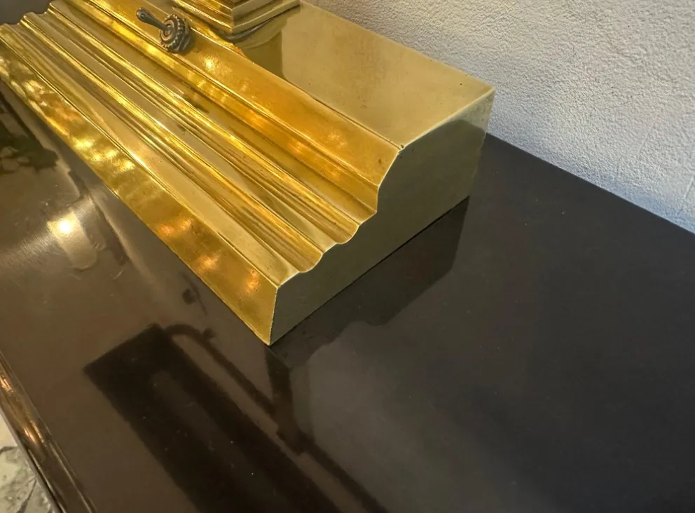 Luminária de mesa antiga Art Deco com base dourada clara, forma estilizada e detalhes na superfície.