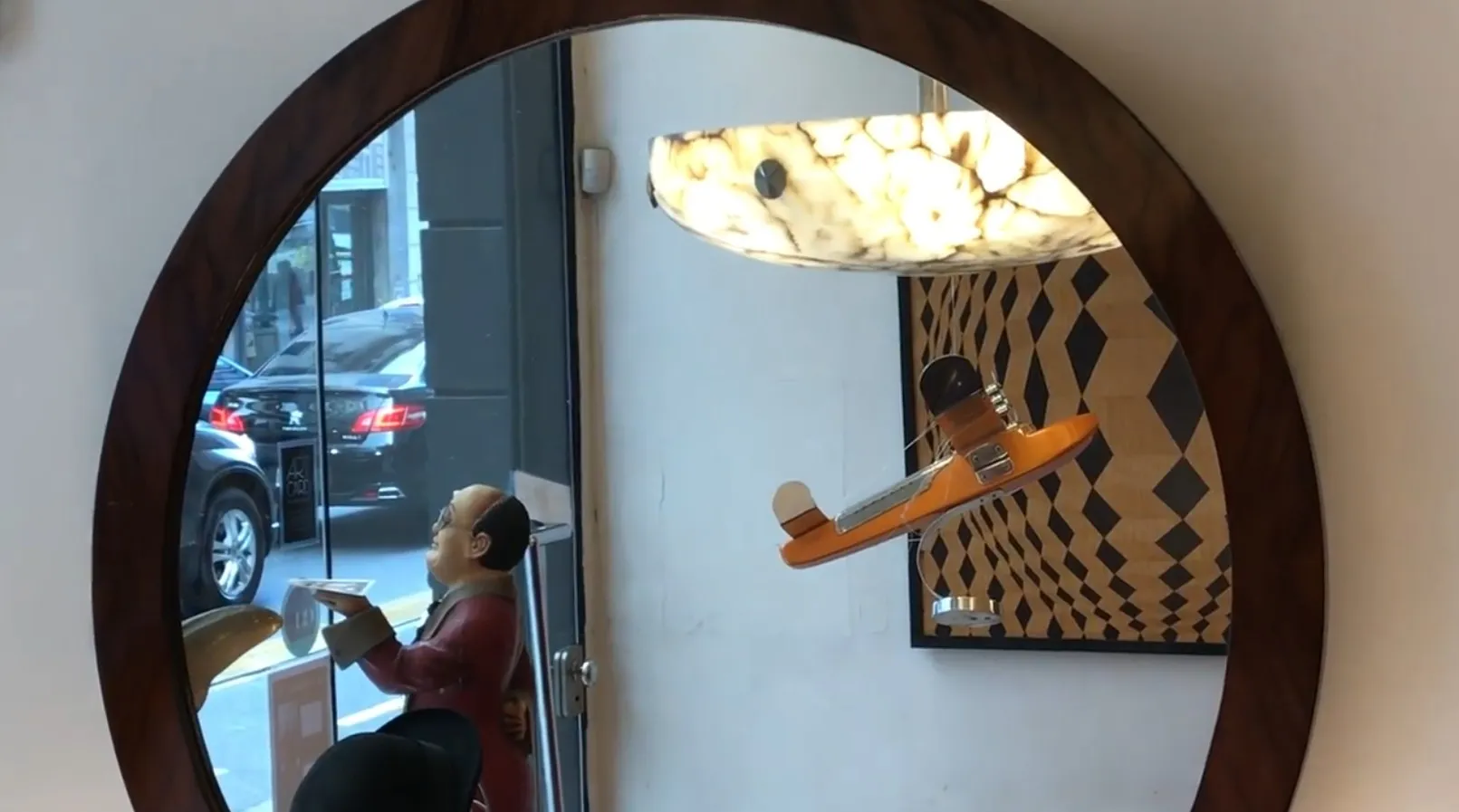 Antique decorative mirror with a figure in the background.