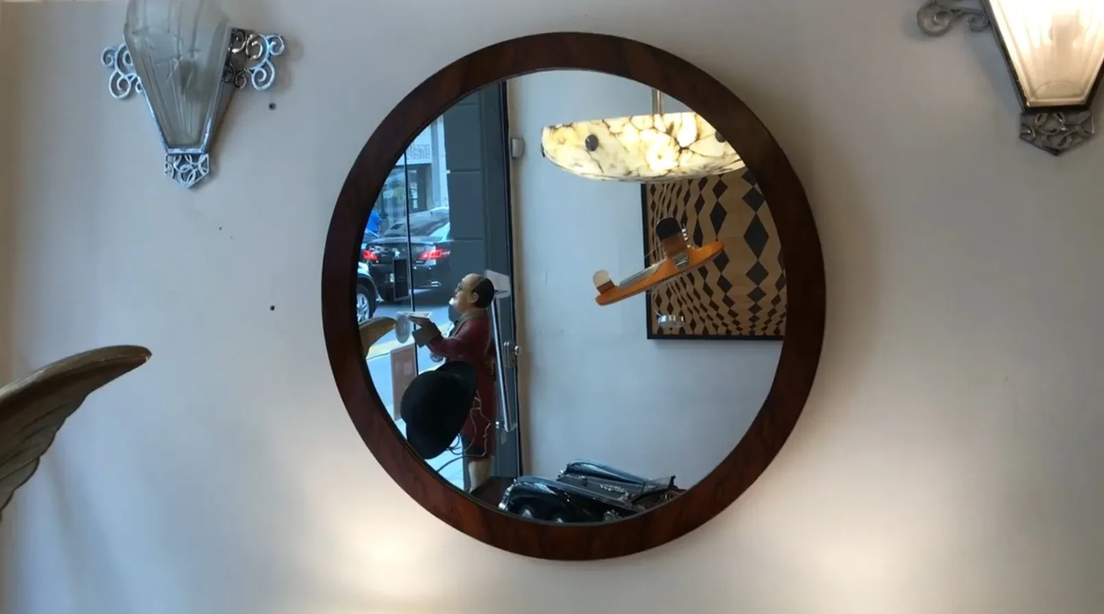 antique round mirror with decorative elements on the wall