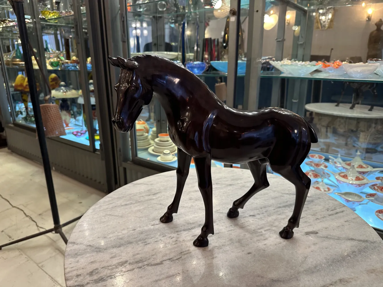 Scultura antica di un cavallo con superficie lucida.
