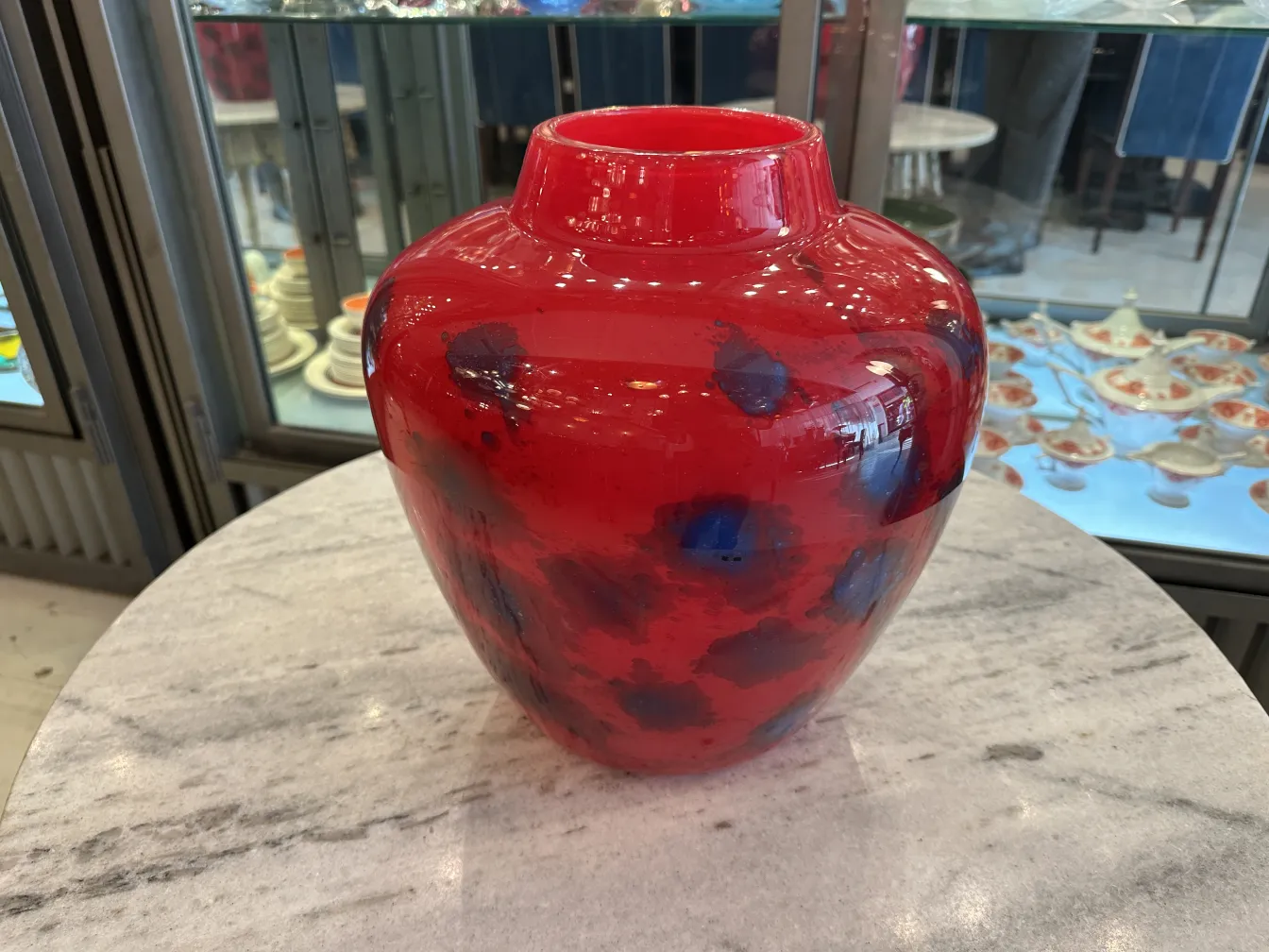 लाल रंग के गिलास का बर्तन जिसमें श्नाइडर का हस्ताक्षर है