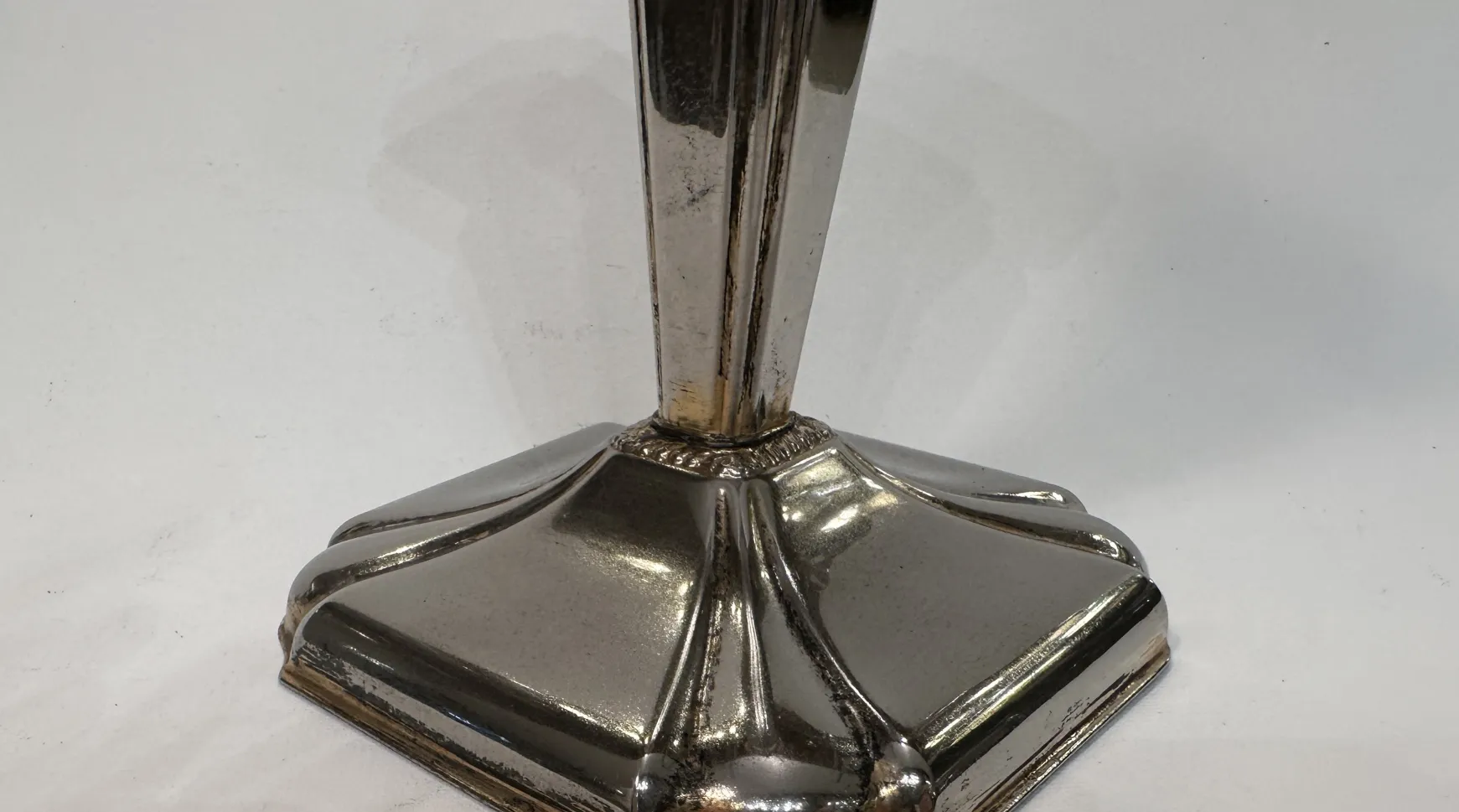 Candelabro antico decorativo con base elegante e design simmetrico.