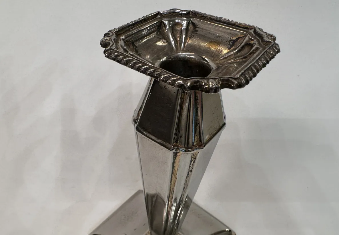 Candelabro antico decorativo con base elegante e design simmetrico.