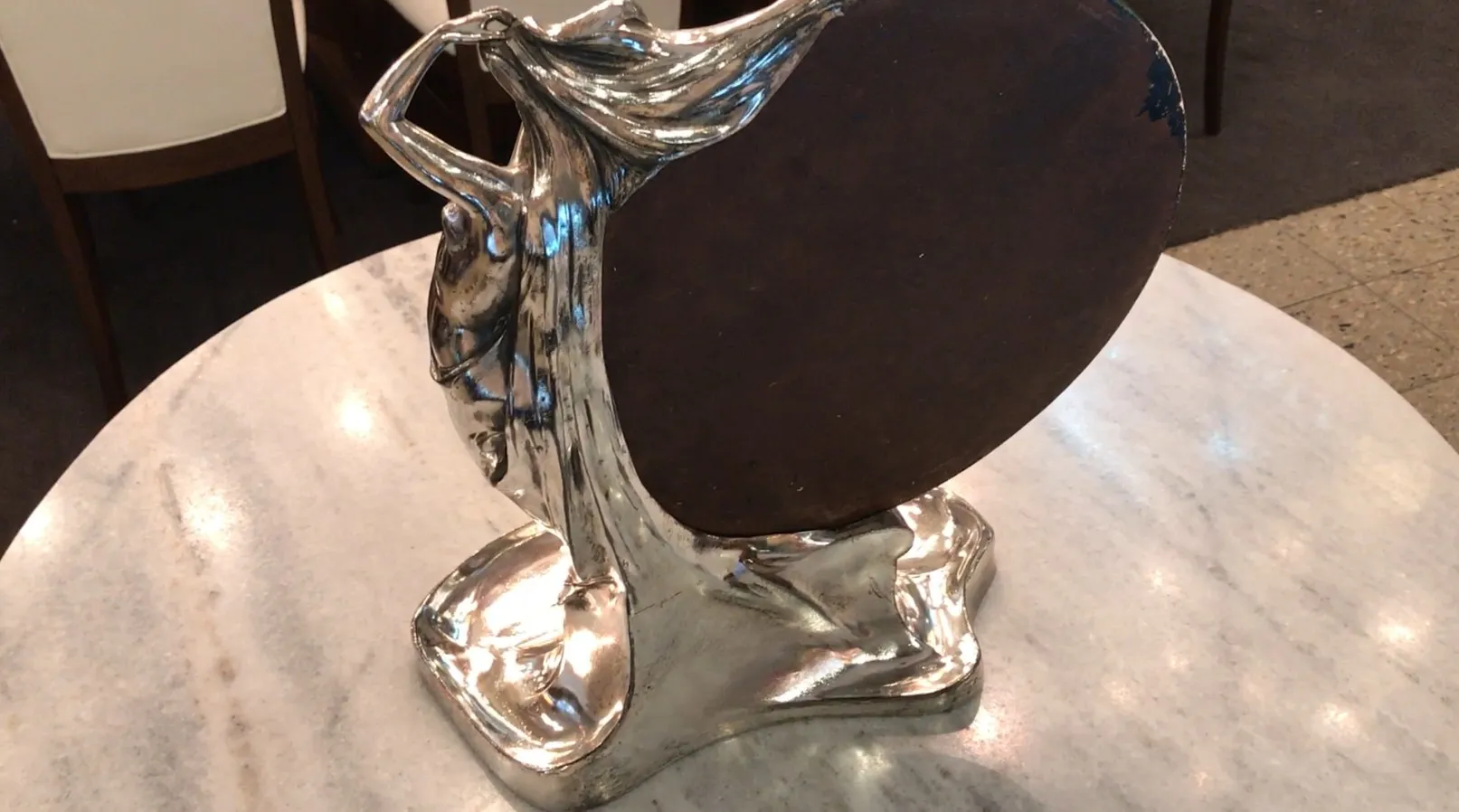 antique mirror with details on base, light background