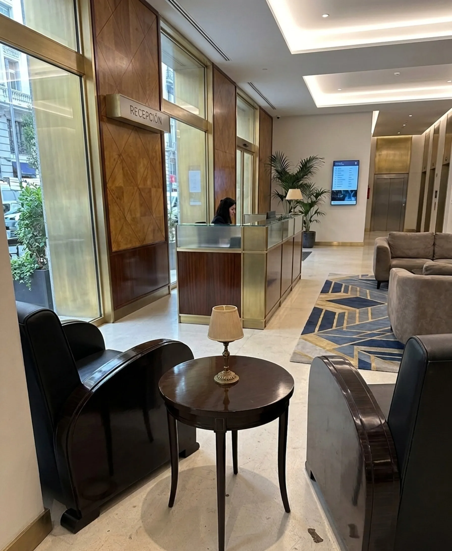 two antique armchairs in a modern reception area, with table