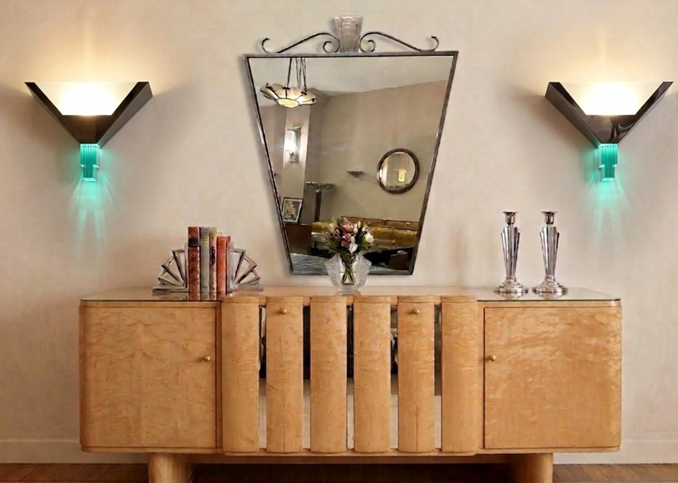 antique pair of sconces in an elegant decor with mirror, books, and flowers