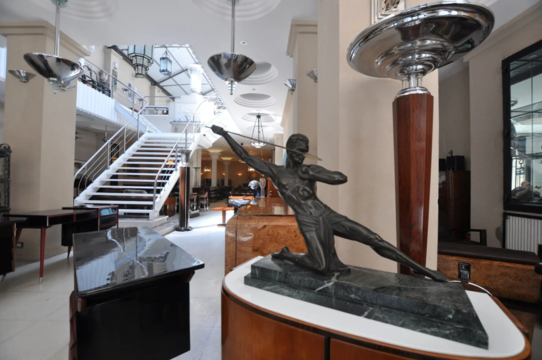 Two antique floor lamps in an elegant space with stairs.