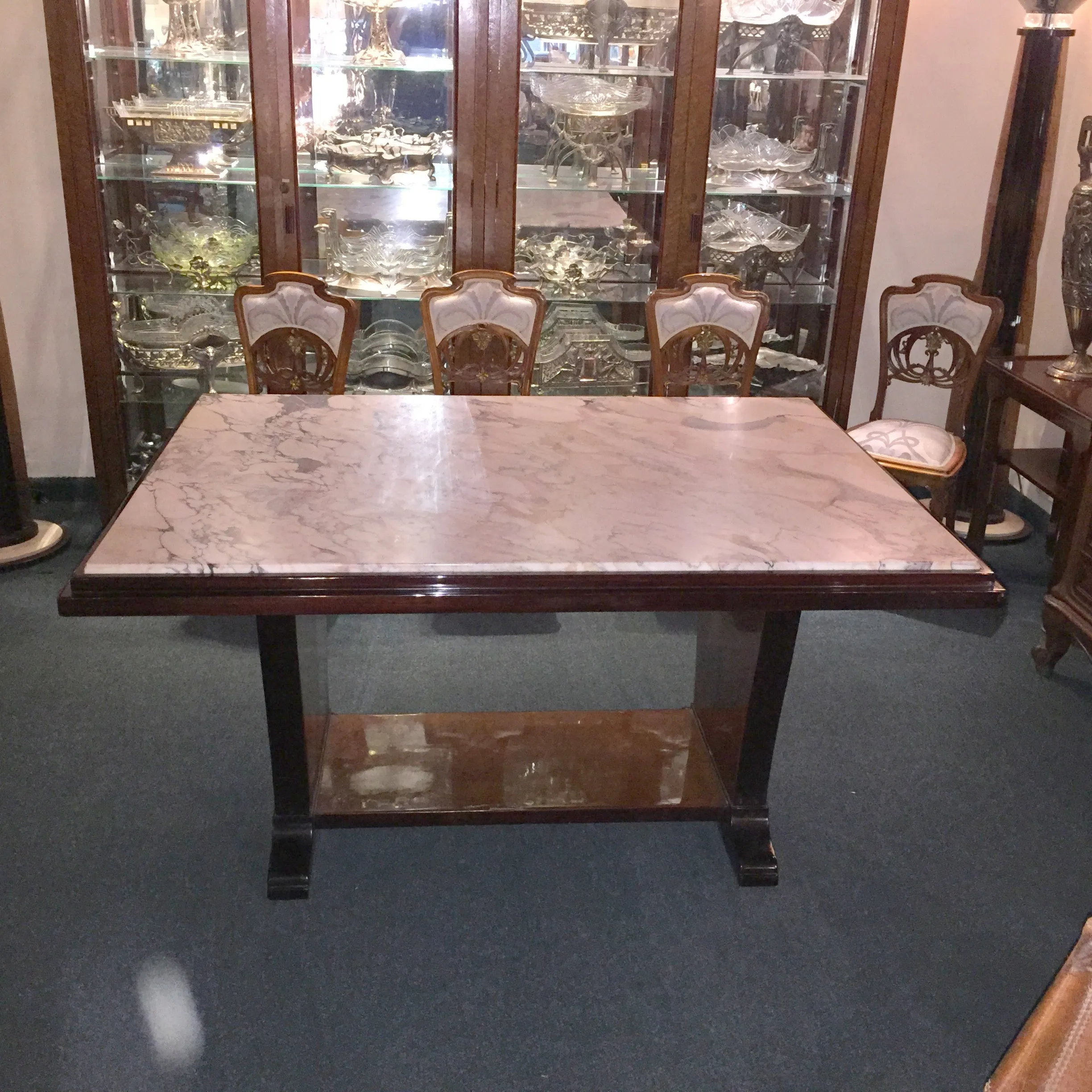 Antique dining table with marble top, elegant setting.
