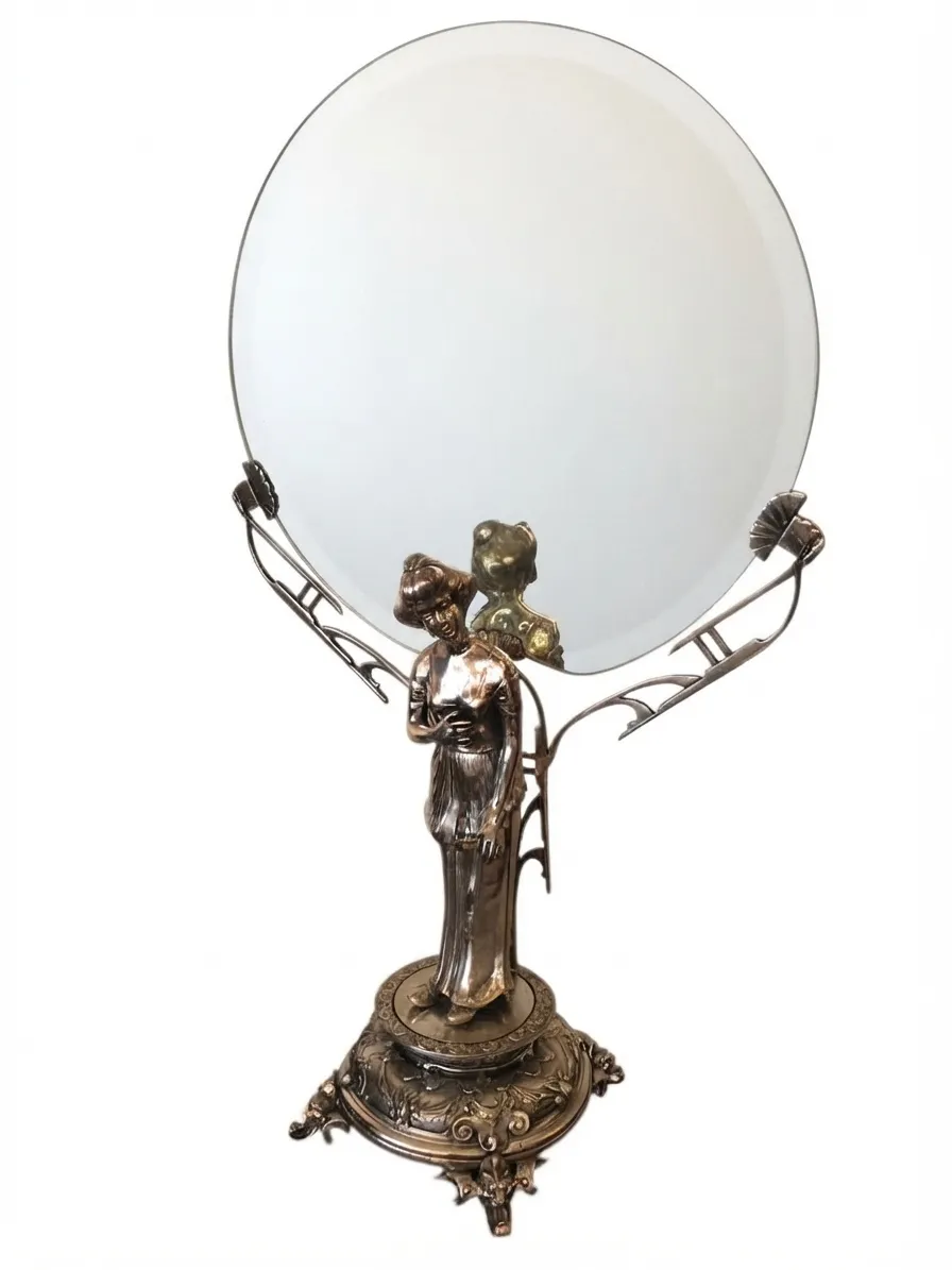 antique mirror featuring decorative figure and elegant base