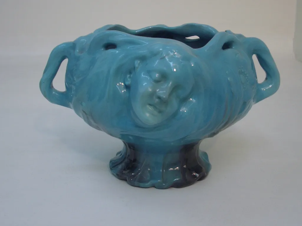 antique planter with relief face, blue color