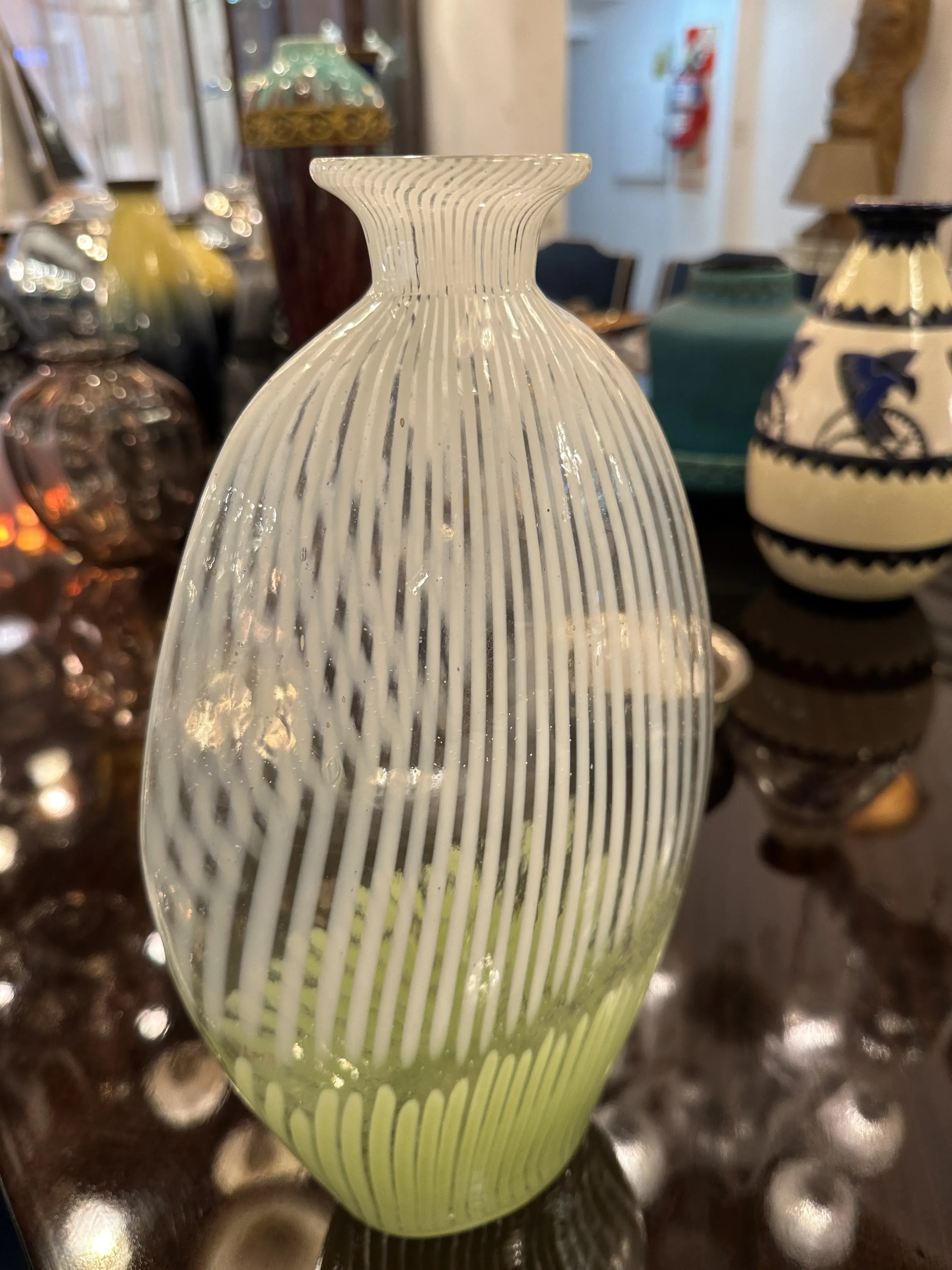 Antico vaso di Murano con design decorativo e forma unica, circondato da altri oggetti