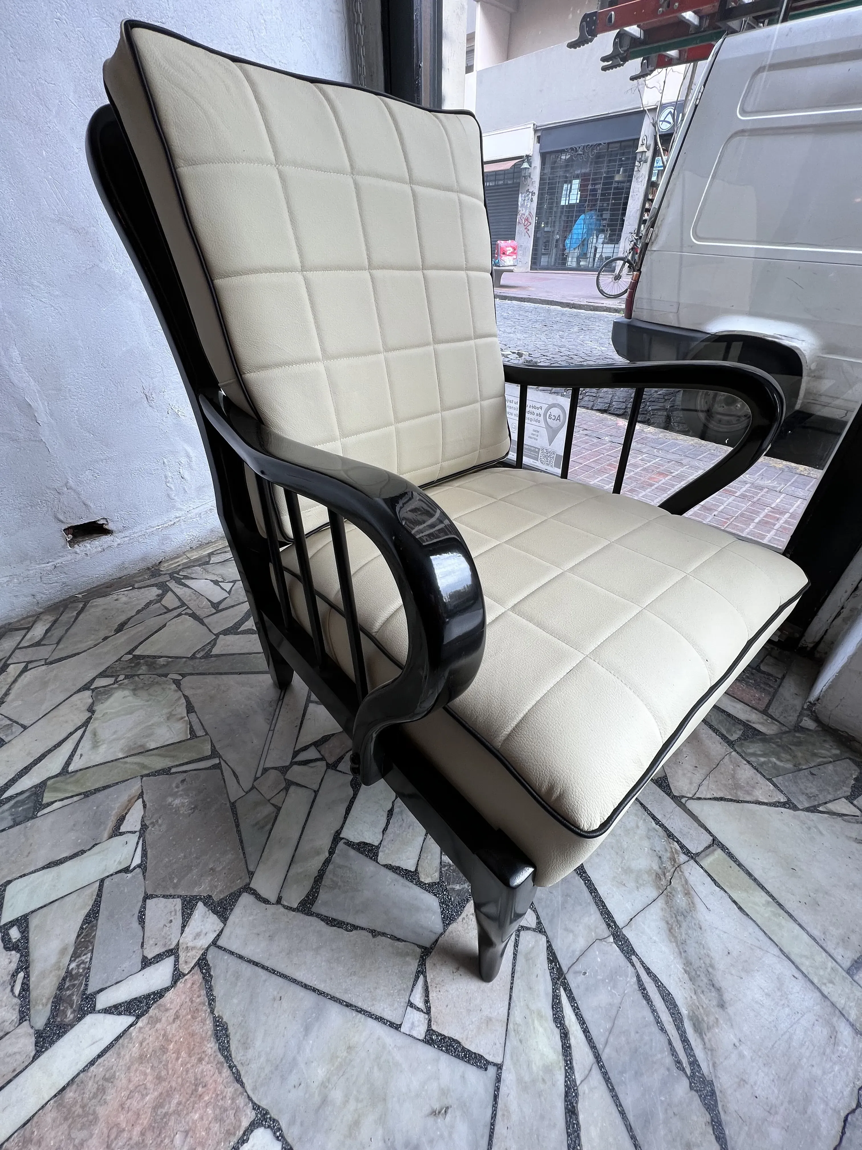 Side view of 2 antique armchairs by Paolo Buffa, featuring classic design and light upholstery, urban background