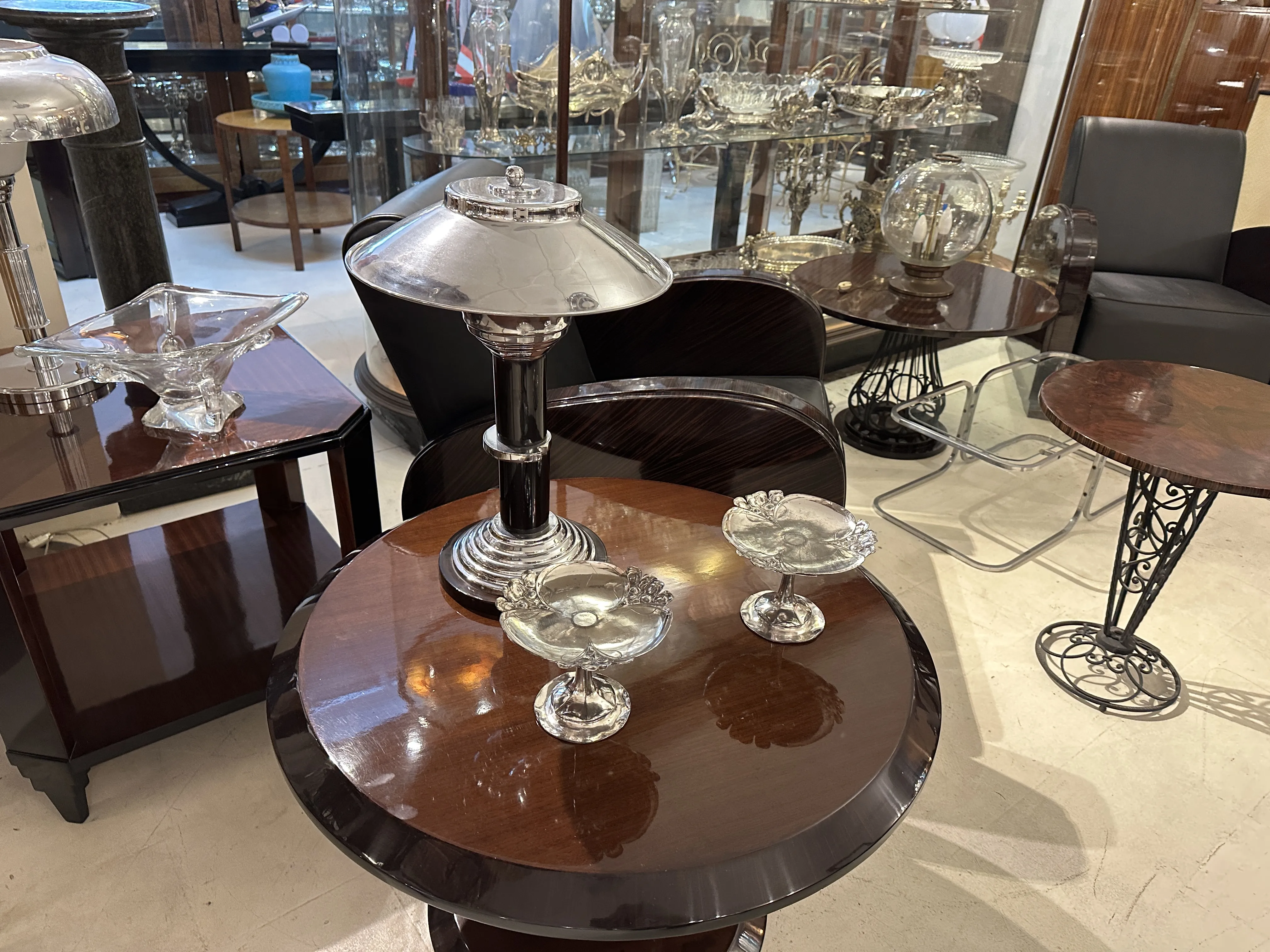 antique card tray WMF on a wooden table, surrounded by other decorative antique objects.