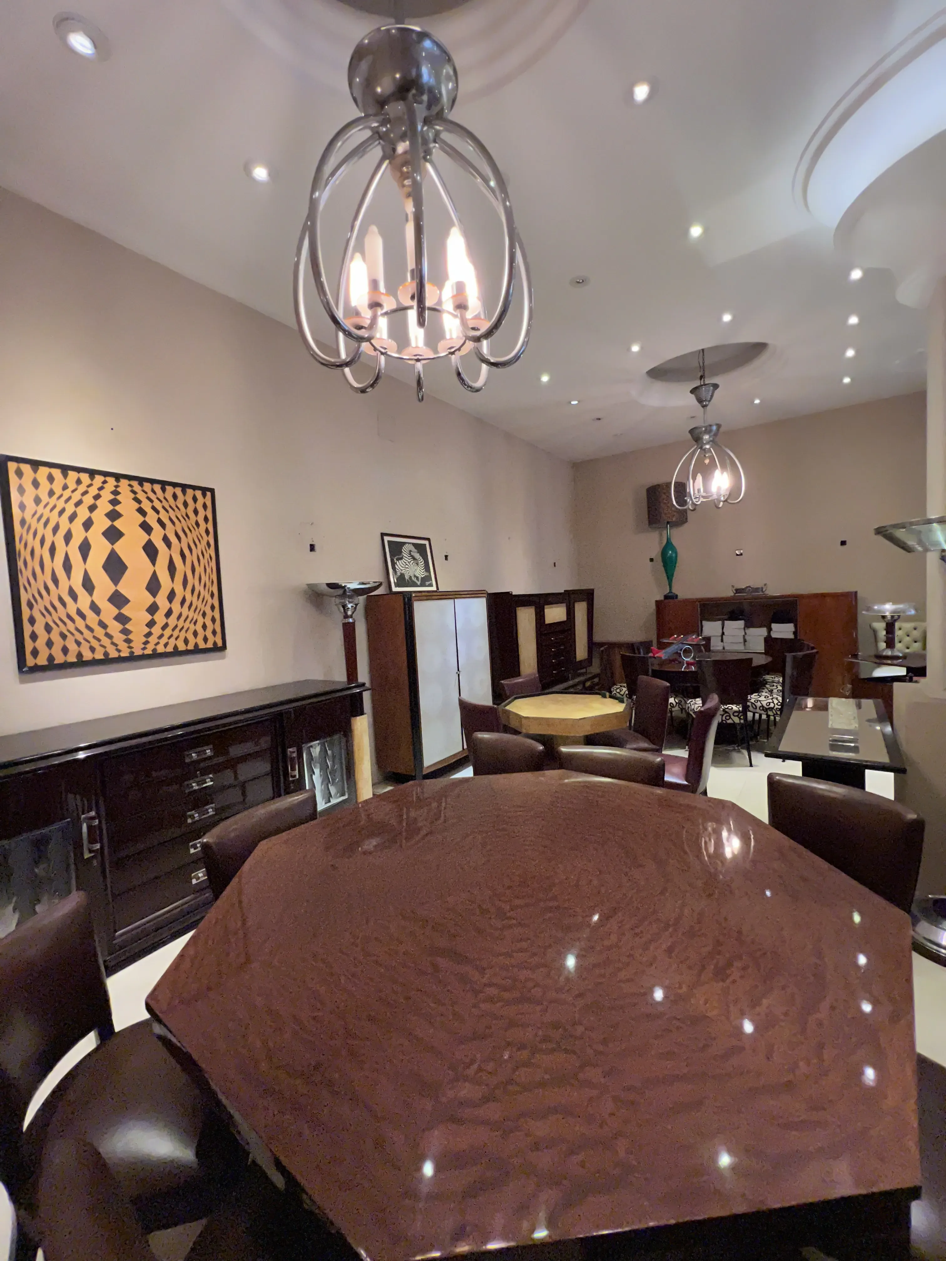 Antique octagonal dining table for 8 people, elegant chairs, modern ambiance, artwork on the wall.