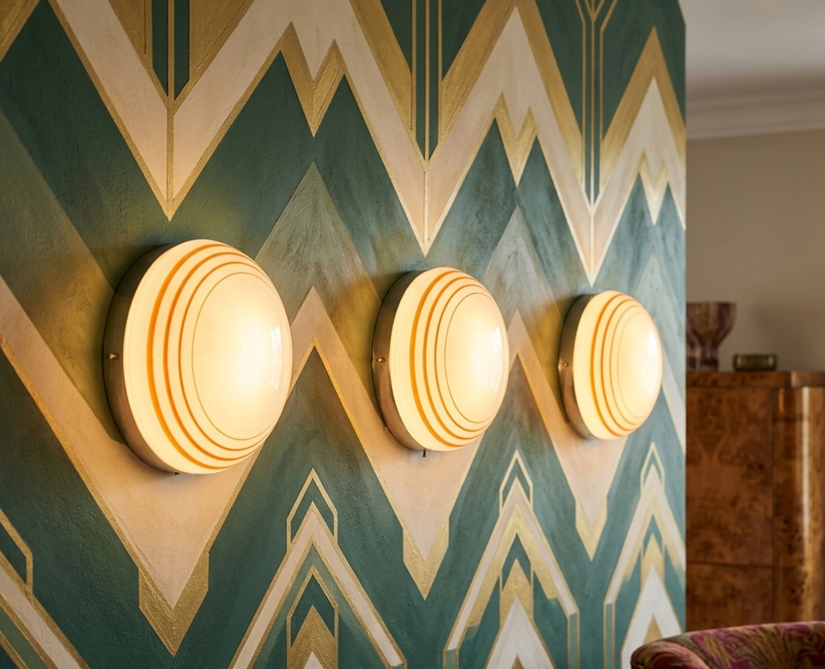 Three antique ceiling lights with rounded design illuminating the wall