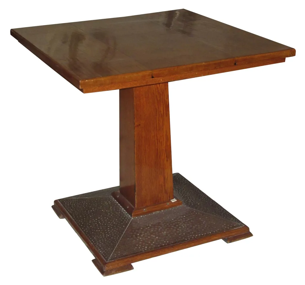Mesa de jantar antiga com base estruturada, adequada para quatro pessoas.