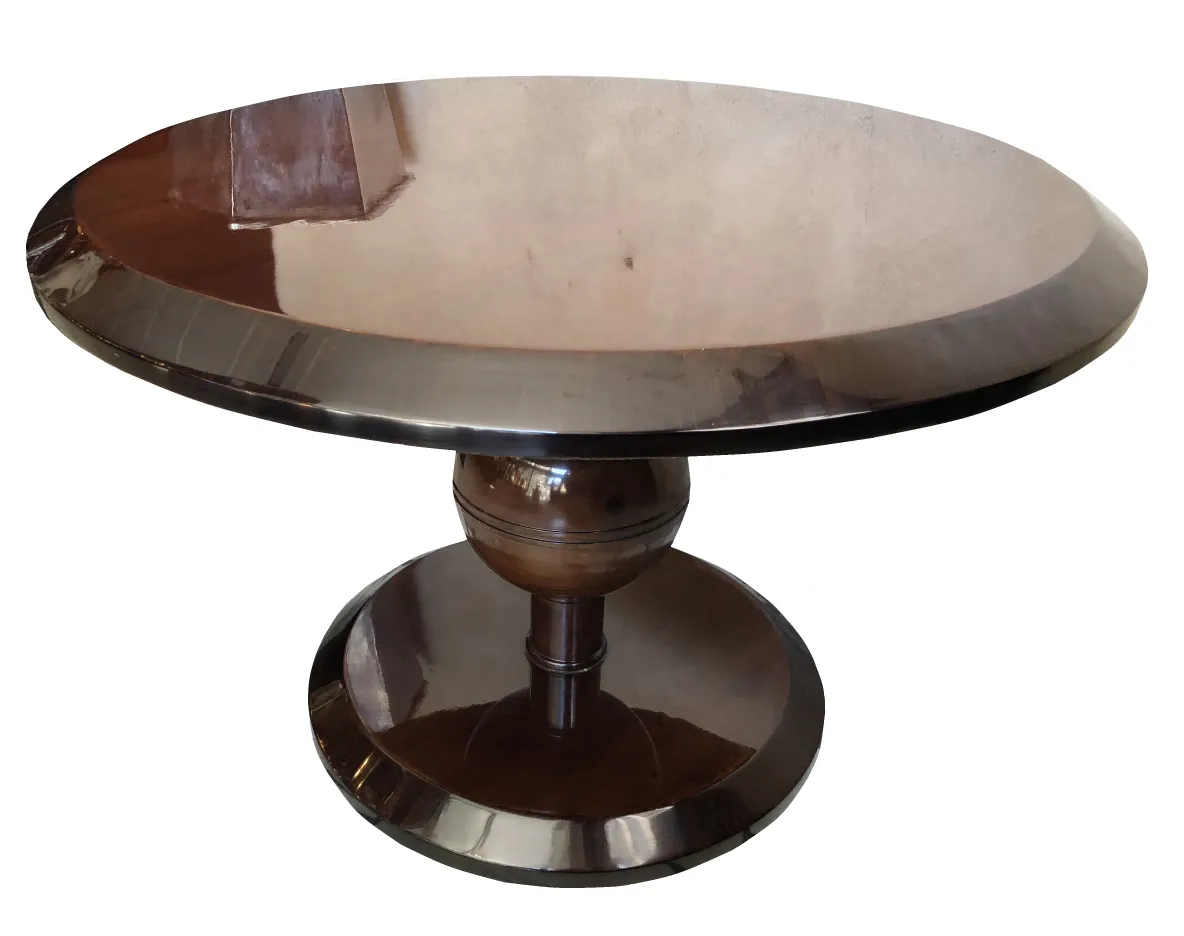 Mesa de centro antiga redonda com pedestal polido, elementos decorativos