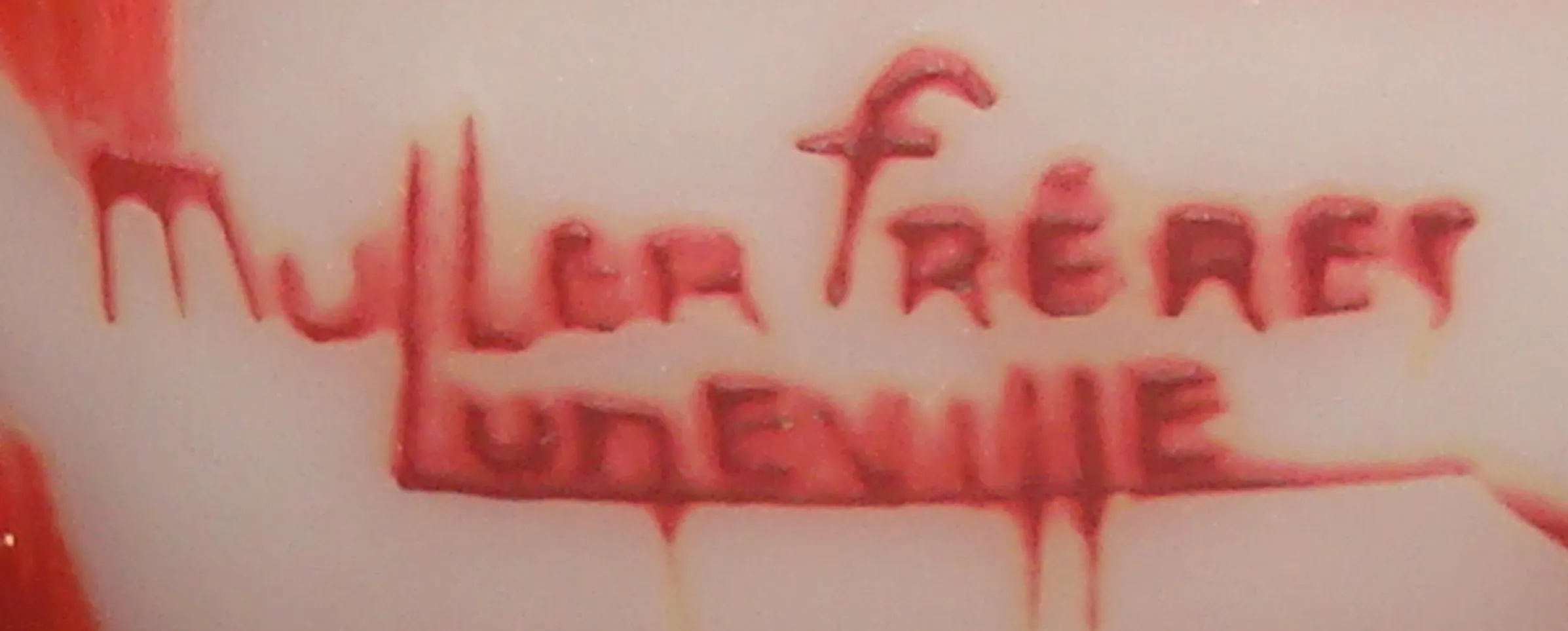 selo antigo com inscrição Muller frères Luneville em vermelho, fundo claro