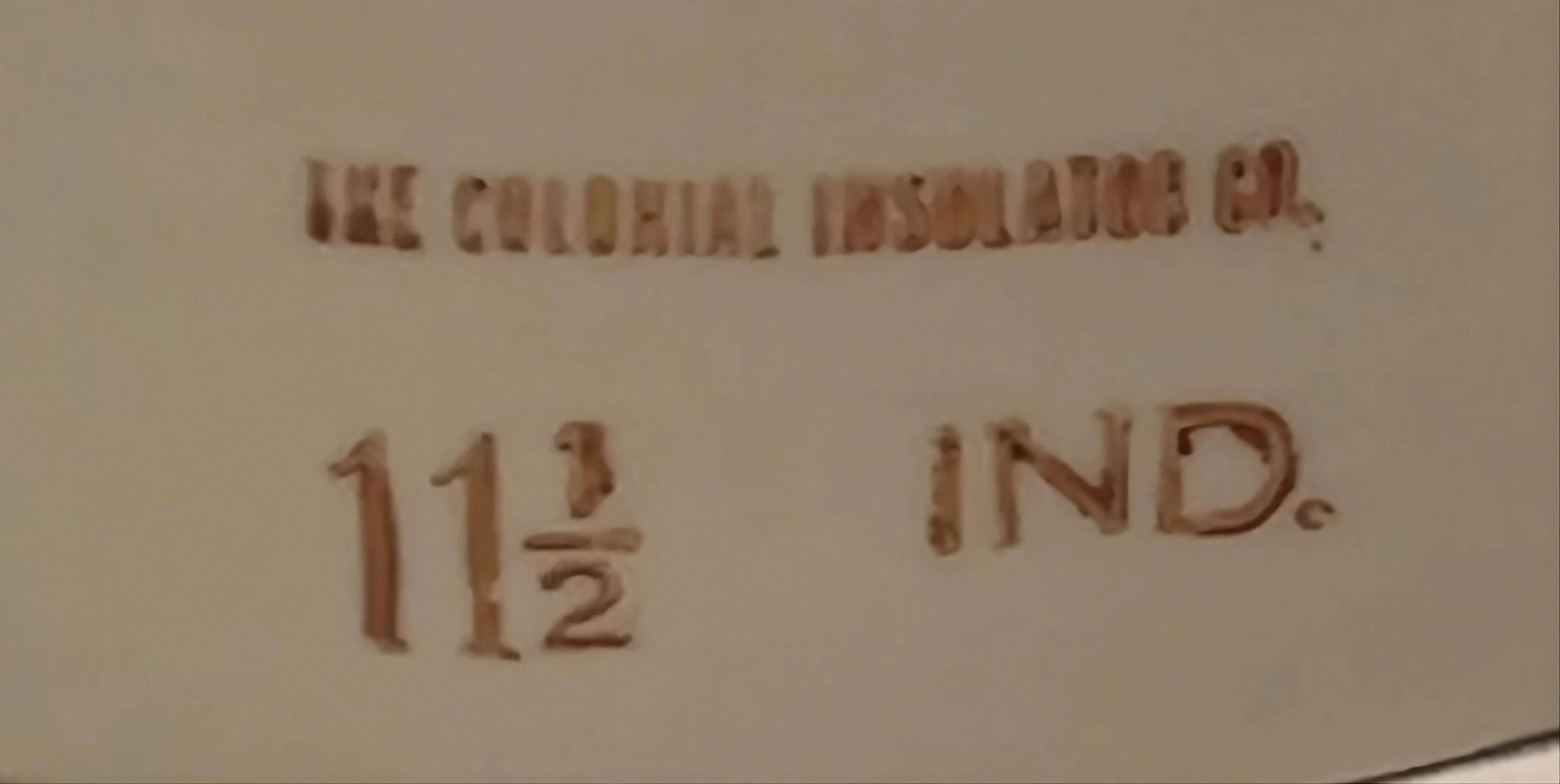 selo antigo com inscrições visíveis de The Colonial Insulator Co.