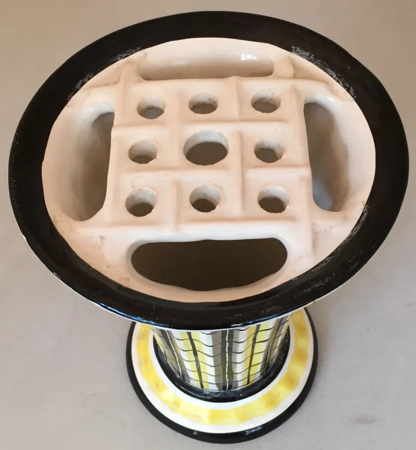 Top view of an antique ceramic with a hole design, on a neutral background.