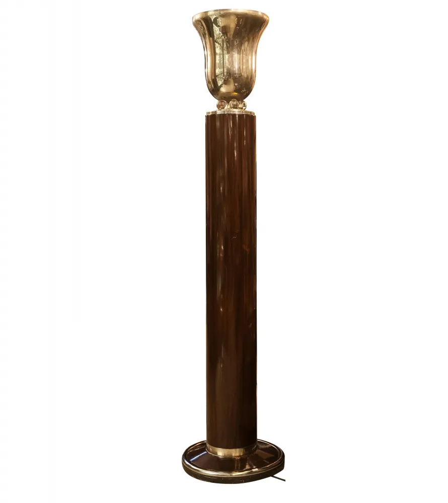 Antique floor lamp with intricate base in an elegant setting.