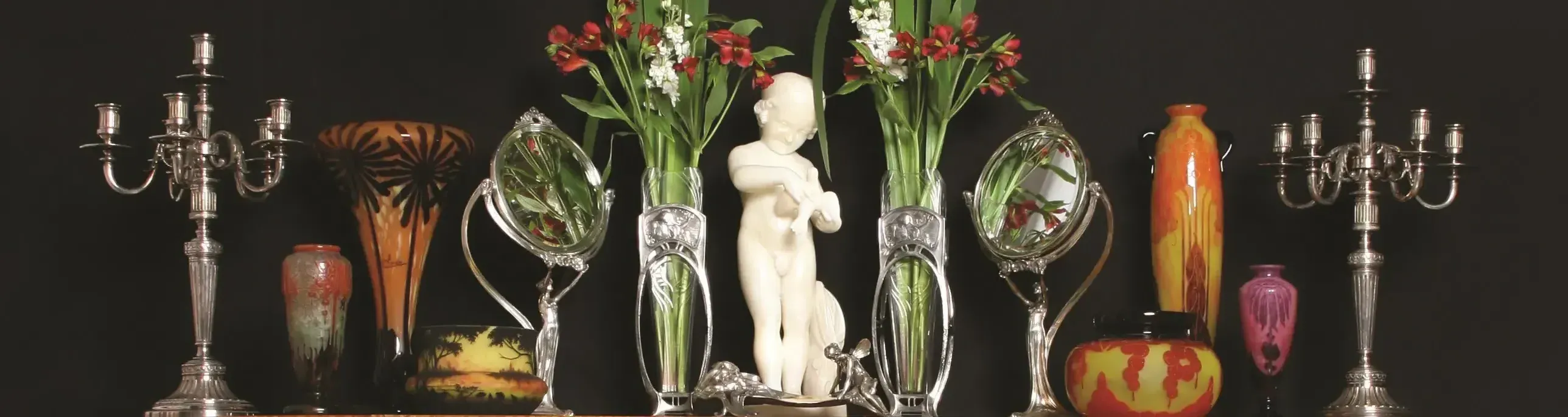 Antique metal candelabra and vases with flowers.