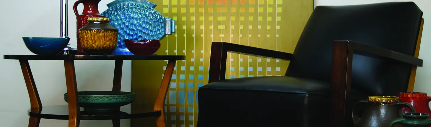 collection of Art Deco style ceramics and porcelain in an elegant setting with leather chairs