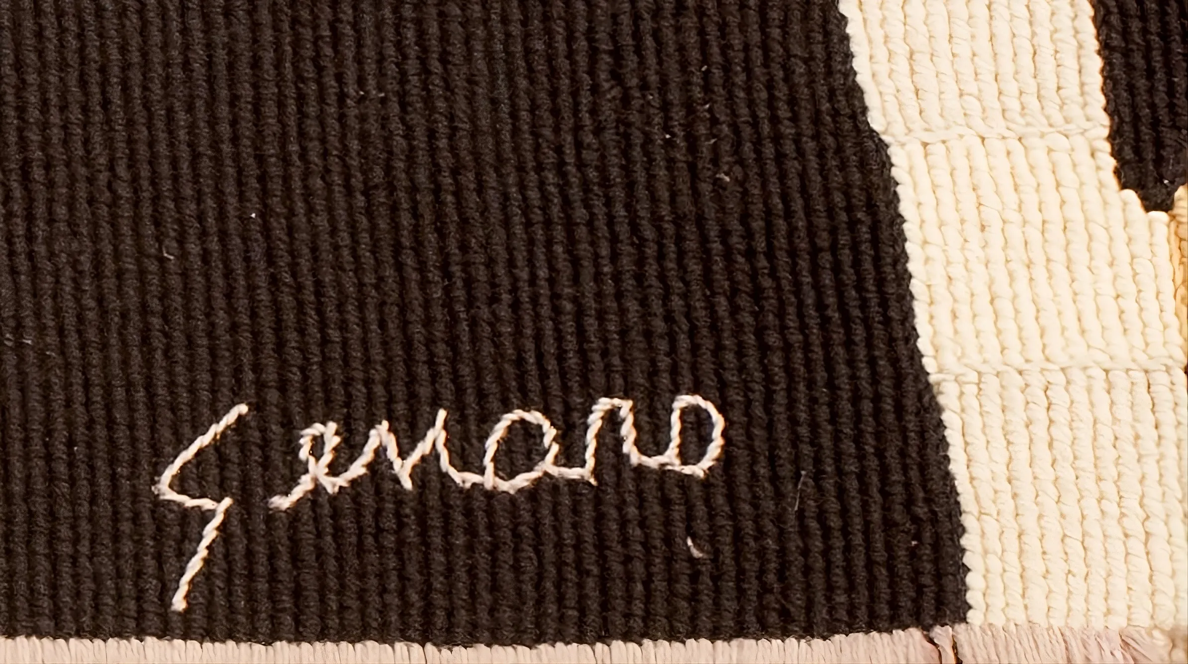 antique seal with name Genaro stitched in light thread