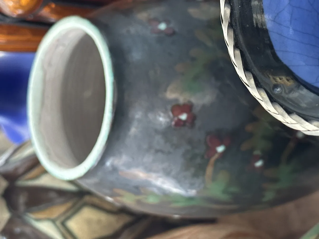 Antica ceramica decorata con fiori in un contesto rustico.