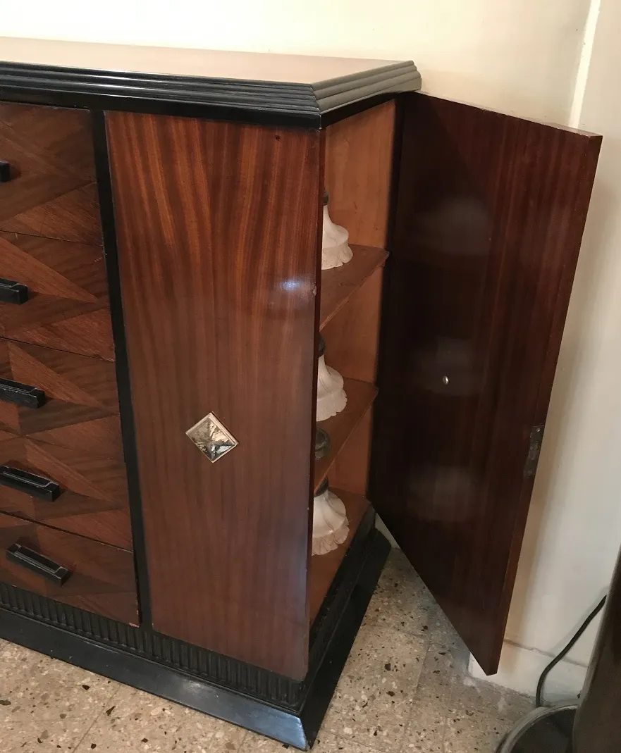 Commode ancienne avec finitions en bois et étagères internes, décorée.