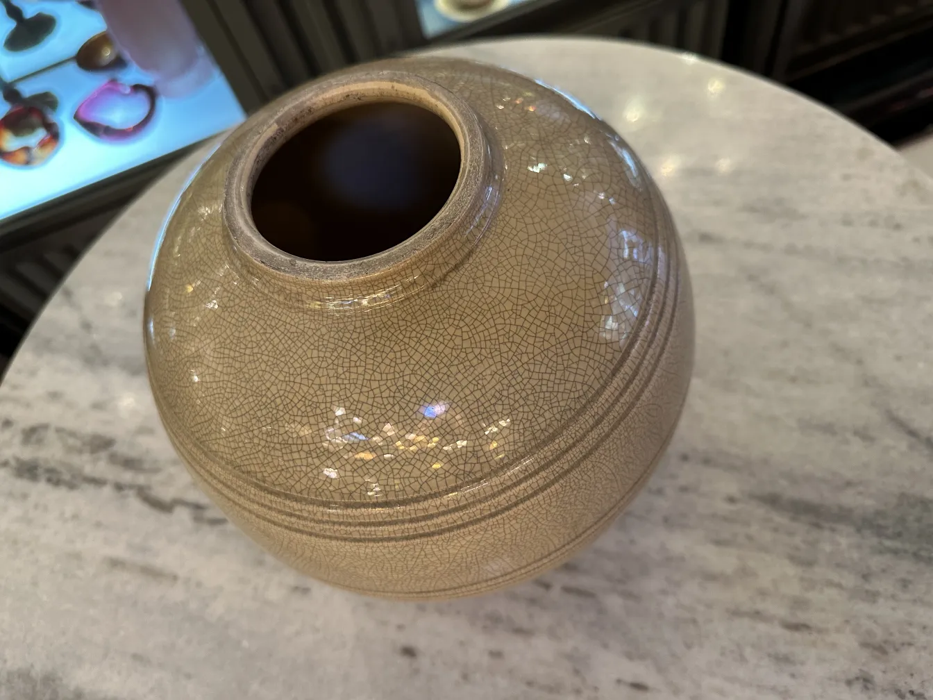 Antique ceramic vase with crackled texture on table.