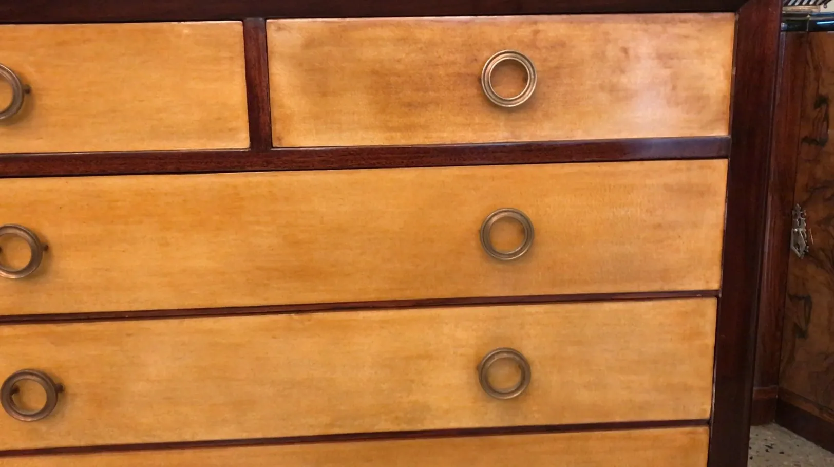 Commode ancienne avec détails en bois et poignées en métal.