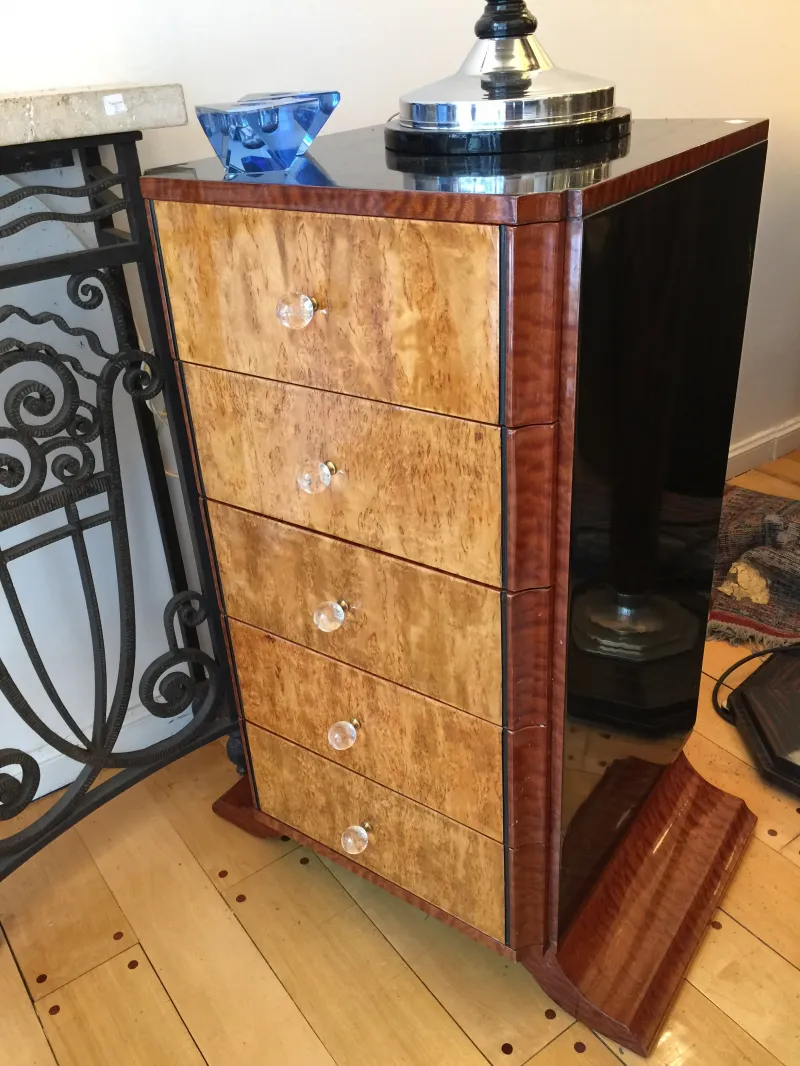 Commode ancienne en bois avec quatre tiroirs et poignées transparentes.