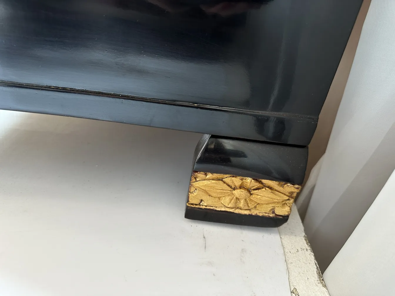 Antike Schublade mit goldenem Reliefblumenfuß.