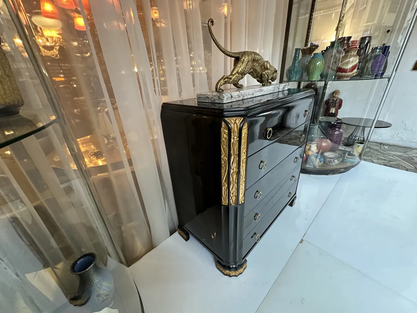 Comoda antigua con detalles dorados y un ambiente elegante.