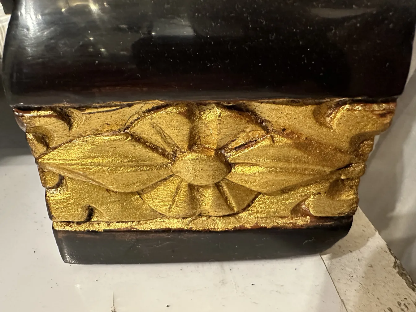 Antique cabinet with golden design and dark wood, elaborate details